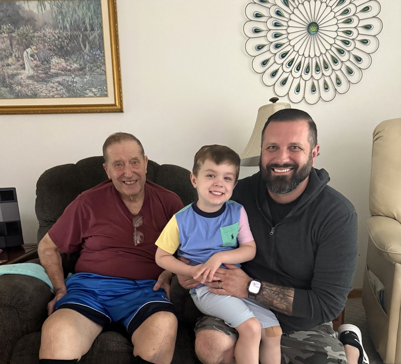 Jeremy Scavazzo seated with his young son and an older relative.