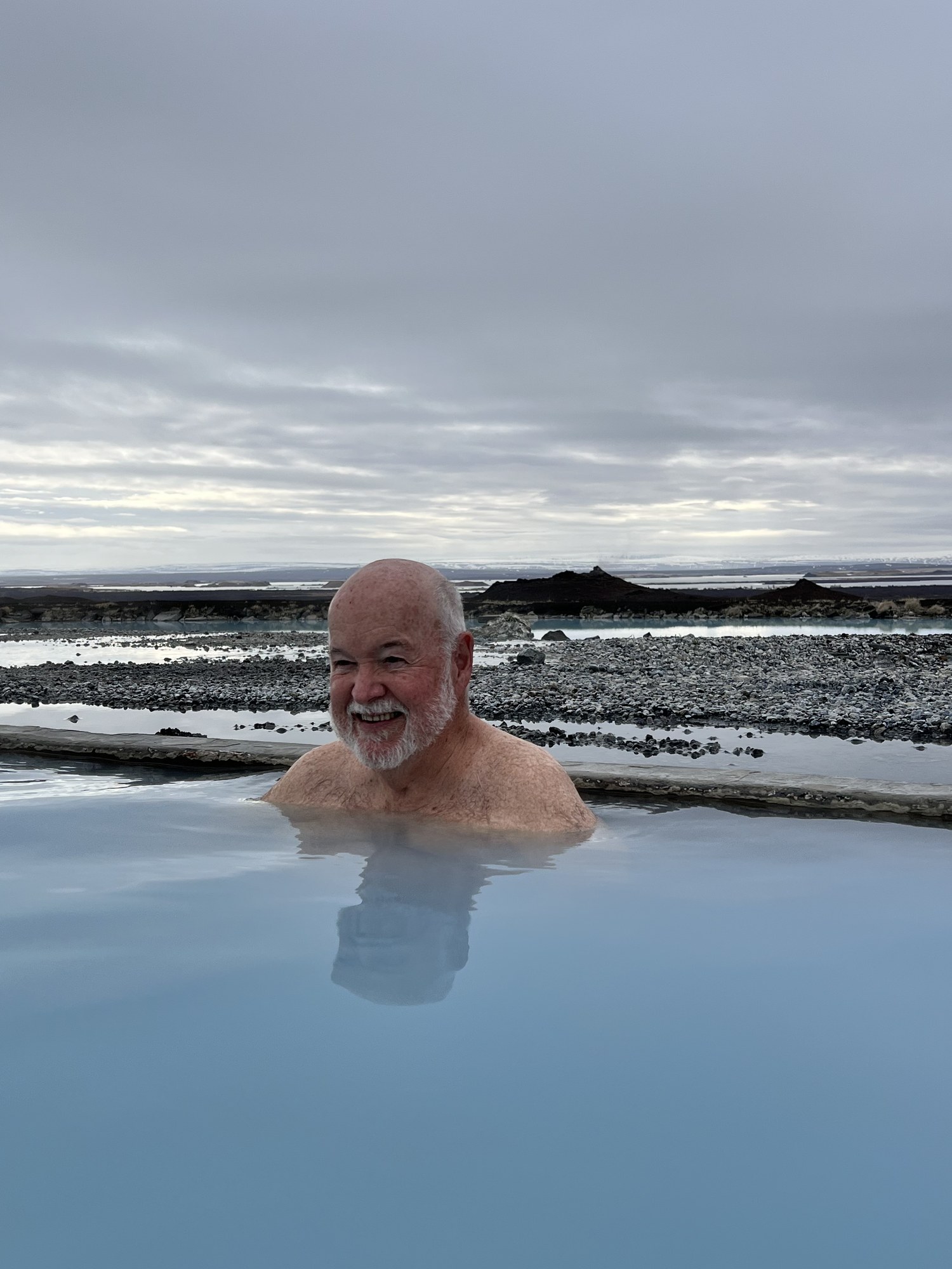 Eugene Sheedy smiling while relaxing in a geothermal hot spring during one of his travels