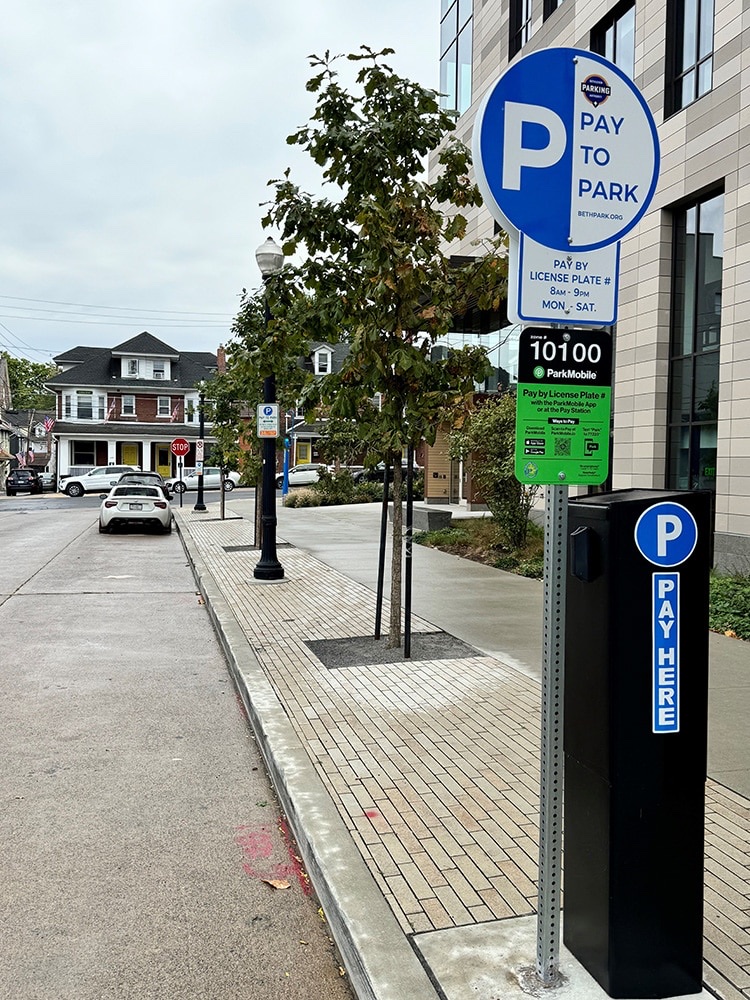 A Bethlehem pay-to-park sign and ParkMobile pay station on a downtown sidewalk