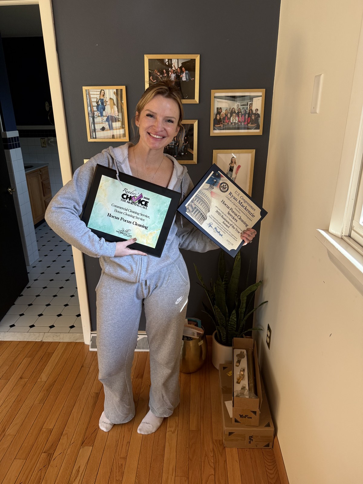 Rose Selvaggio holding two framed awards at home.
