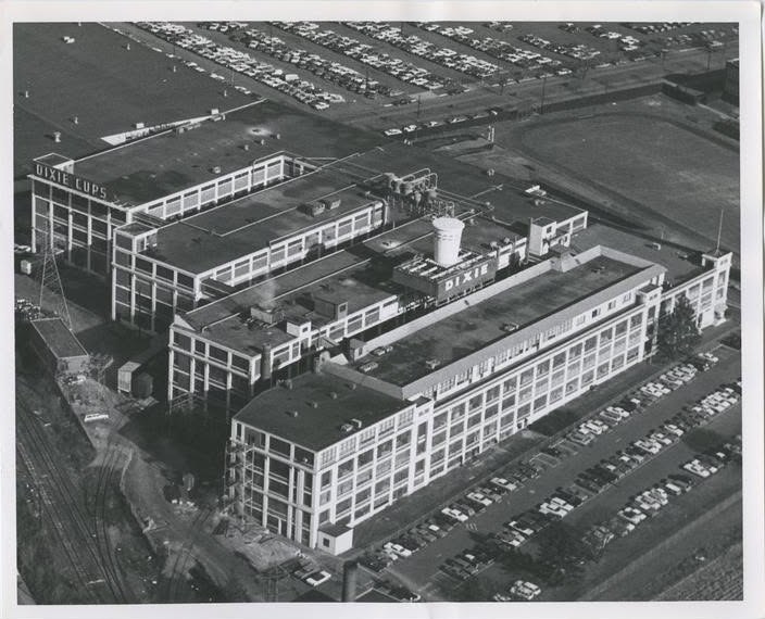 Aerial photograph of the expanded Dixie Cup complex with full parking lots and a DIXIE CUPS rooftop sign