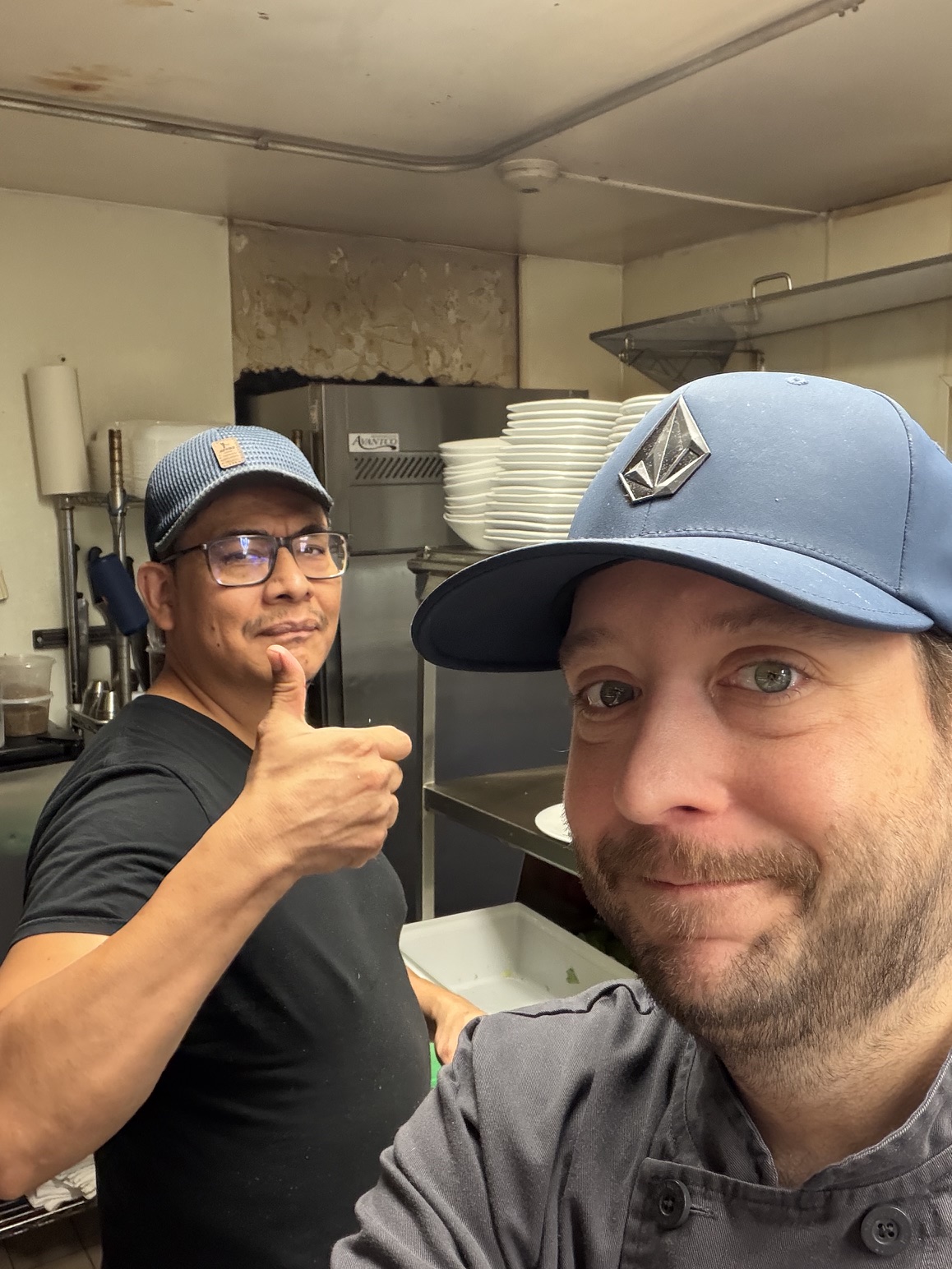 Two cooks in the Limeport Inn kitchen, one of them giving a thumbs up.