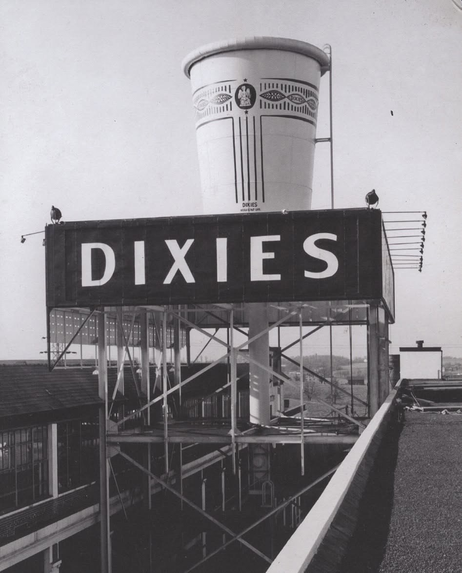 The rooftop Dixie Cup water tower above the factory sign, photographed in black and white