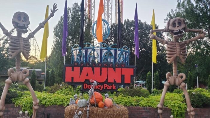 Two giant skeleton figures flanking the Halloween Haunt sign at the Dorney Park entrance