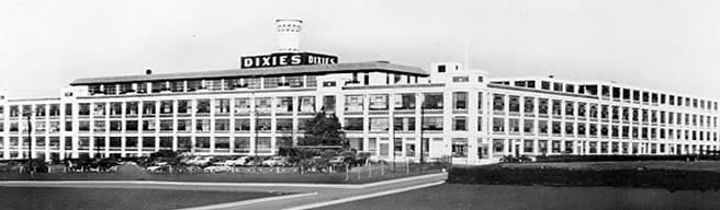The Dixie Cup plant in Wilson Borough at its height, a long white factory with the rooftop sign and parking lot full of cars