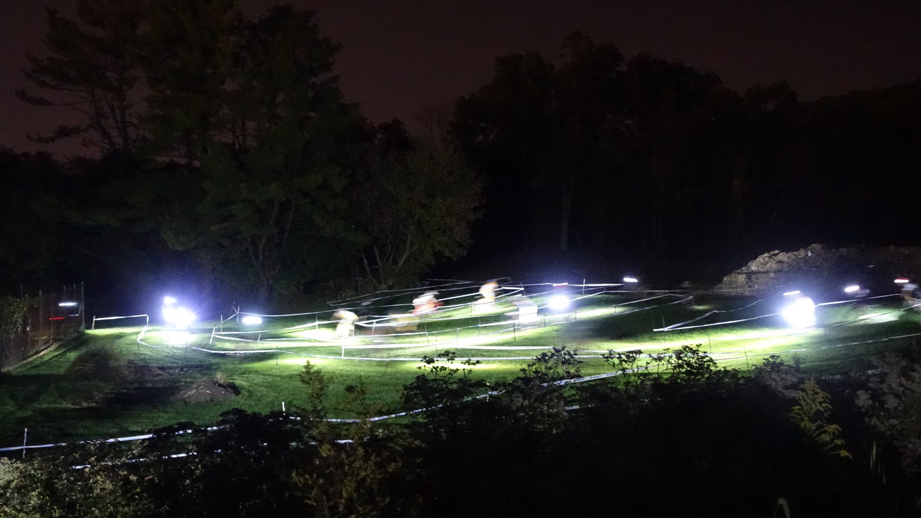 Bike lights streak across the Fifth Street Cross course at night