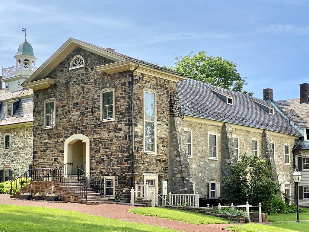 A stone Moravian church building with a white cupola and arched entrance