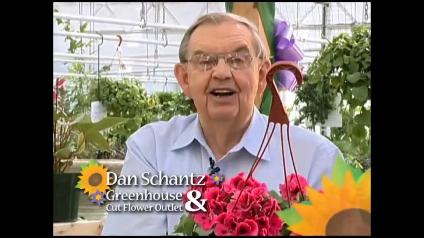 Dan Schantz in his greenhouse holding flowers