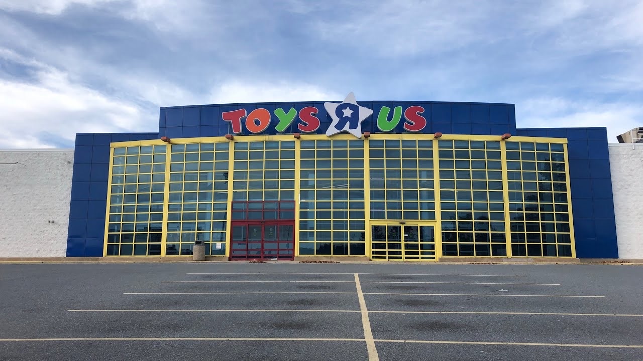 A closed Toys R Us store with an empty parking lot