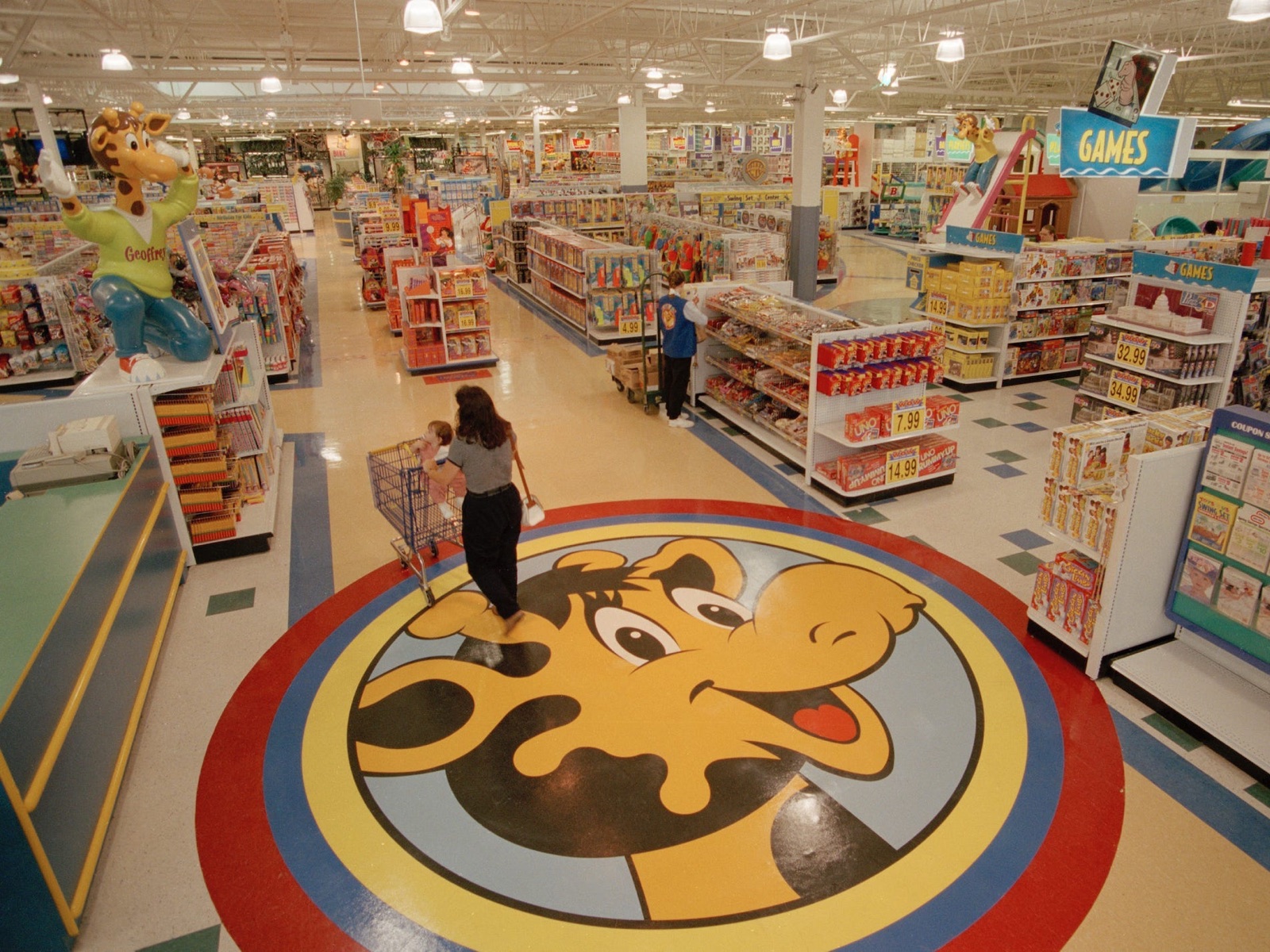 Wide aisles and stocked shelves inside a Toys R Us superstore